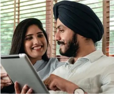 a man and a woman are looking at a tablet