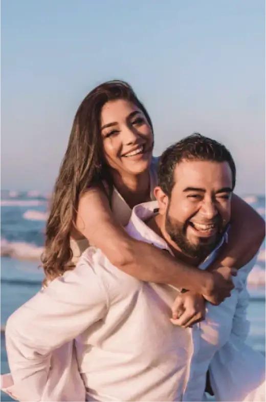 a man holding a woman on the beach