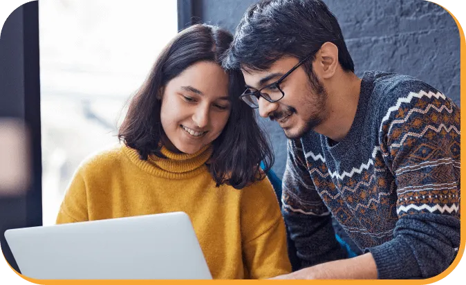 a man and a woman looking at a laptop