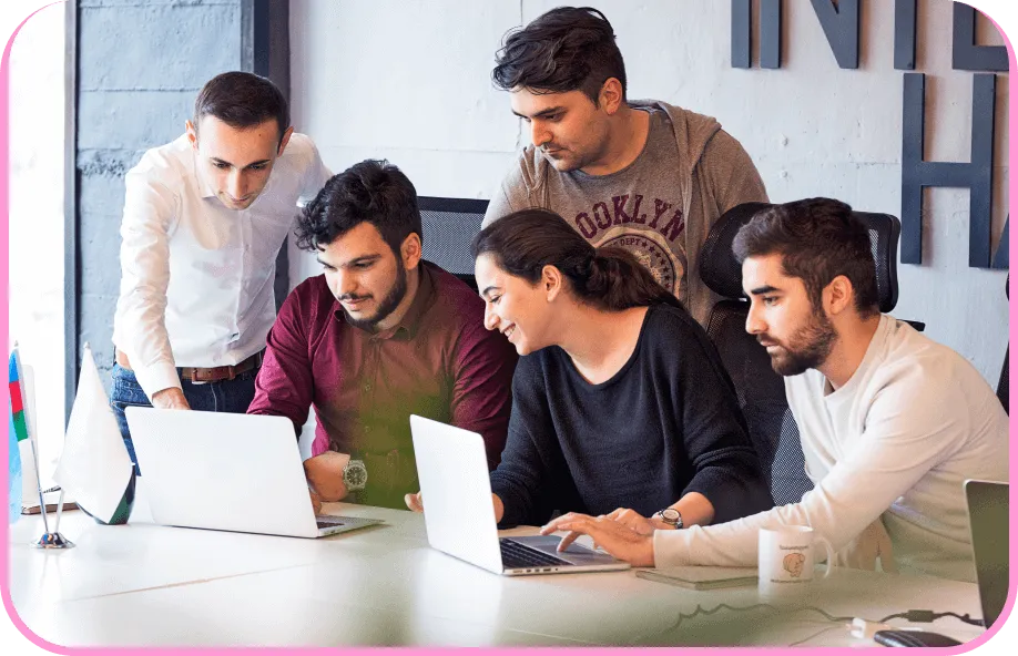 a group of people looking at a laptop