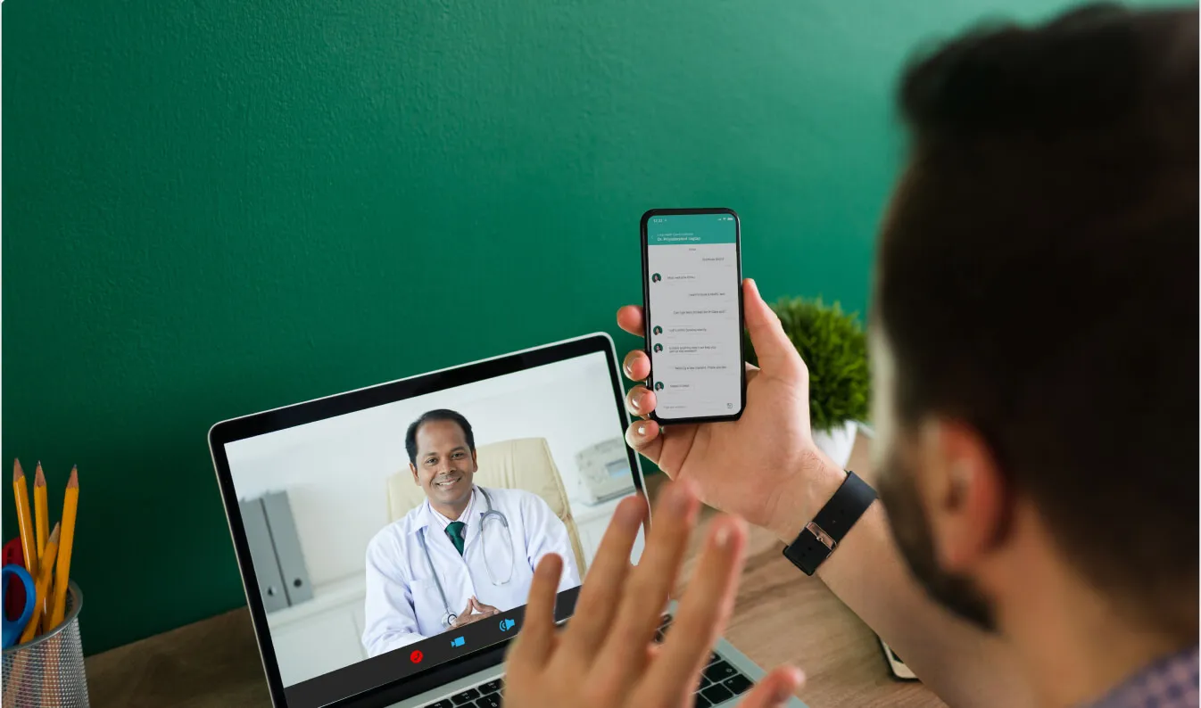 a man holding a cell phone up to a laptop
